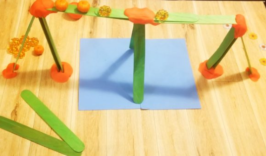 fall stem activities shows a bridge made from popsicle sticks and playdough.