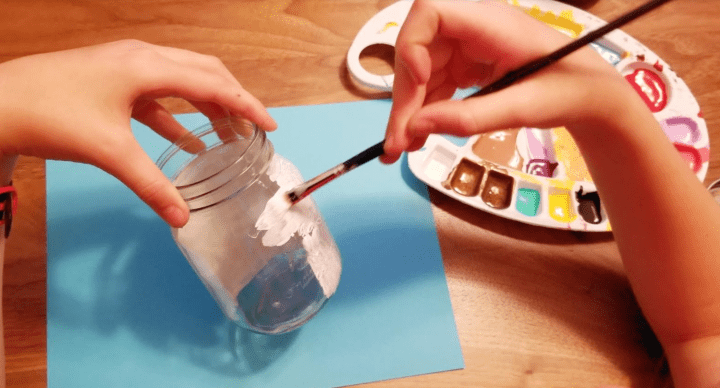 Mason jar crafts and a child painting a jar white