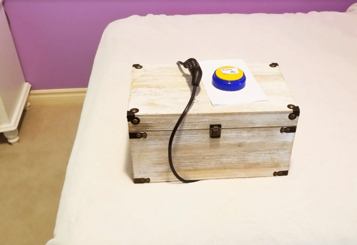 kids escape room shows a locked box on a bed with a button and sheet on top