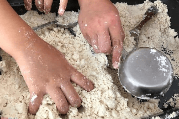 sensory play shows a child playing in moon sand