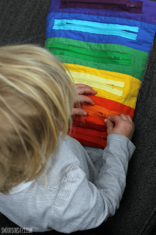 sensory activity shows a child playing with rainbow zippers