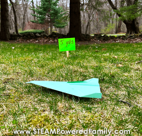 paper airplane shows a green paper airplane on the grass.