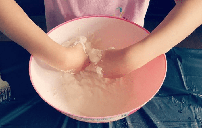 paper mache mix being mixed by a child