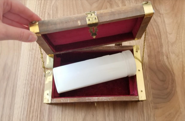escape room game shows a person opening a treasure chest with a container with white liquid in it