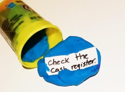 escape room ideas shows a play dough container on its side with the note mushed into the dough.