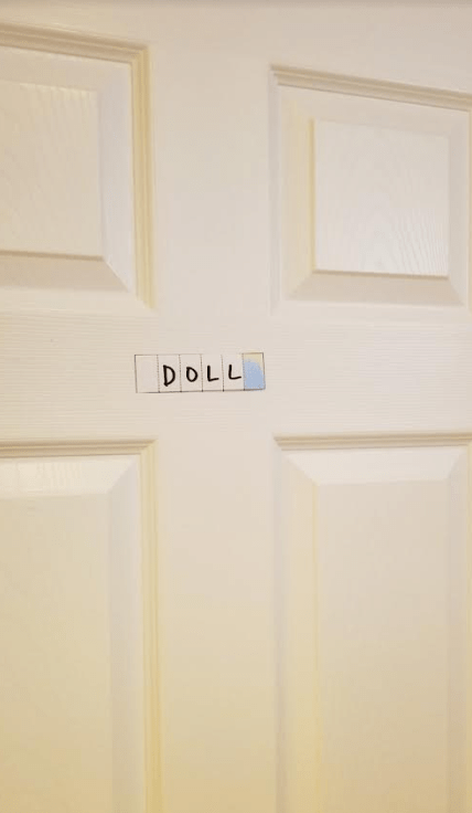escape room for kids shows the word 'doll' on paper stuck to a door