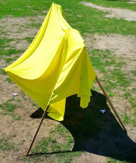 summer STEM activity shows a tent made from a sheet of fabric and sticks