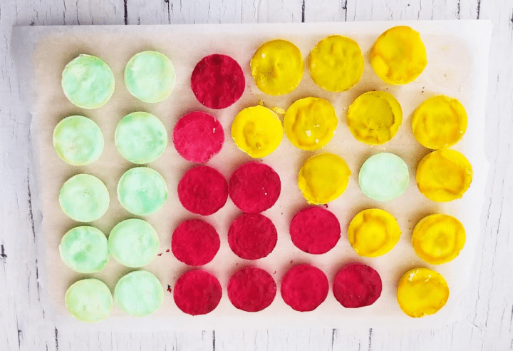 fizzing apple science experiment shows rows of red, green and yellow baking soda pucks.