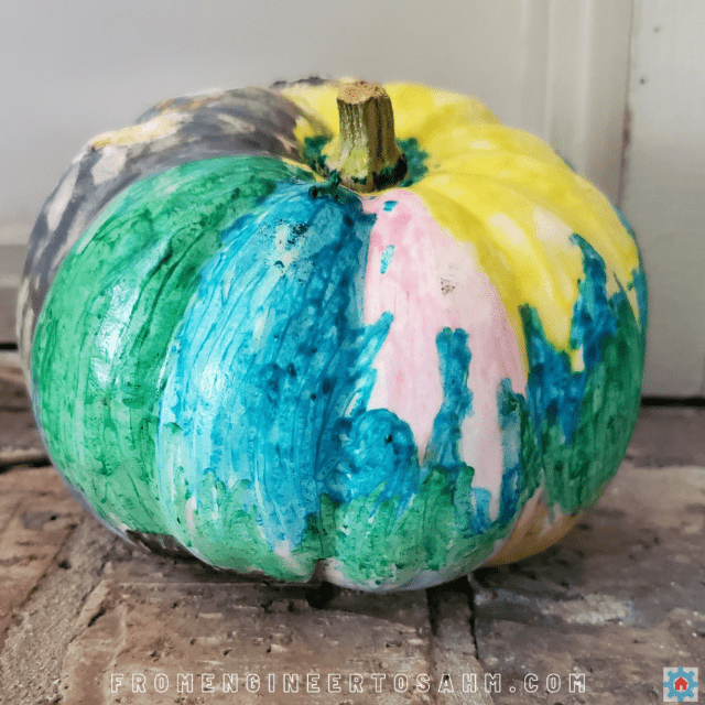 fall science experiment shows a colorful pumpkin with crayon on it.