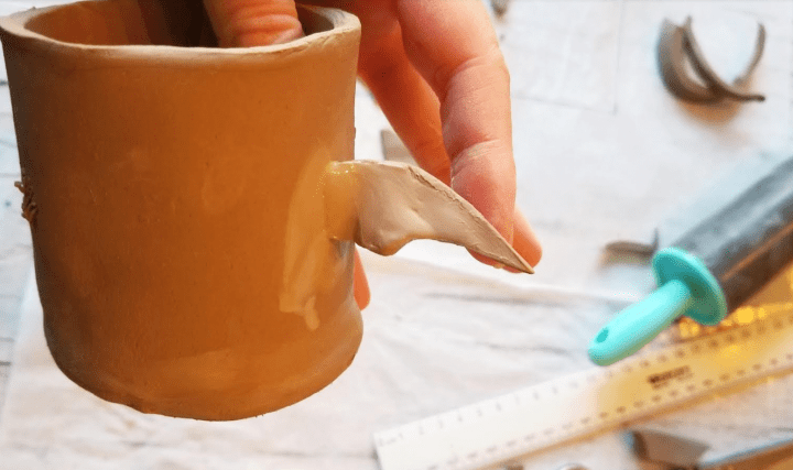 DIY clay crafts shows a bat wing attached to a clay pot.