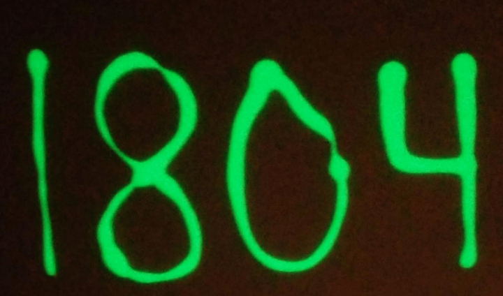 quick and easy escape room puzzles shows the numbers 1804 glowing on a black background.