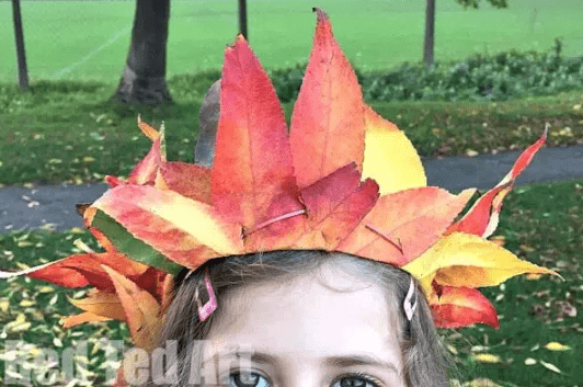 outdoor learning shows a child wearing a colorful crown made of leaves.