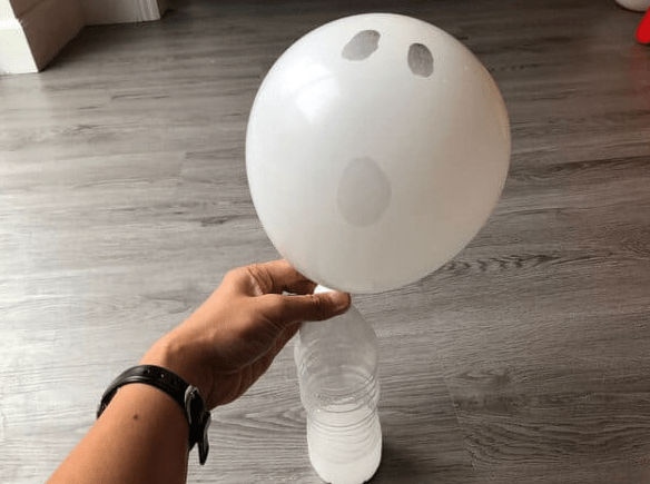 Halloween stem activity for kids shows a ghost balloon attached to a water balloon.