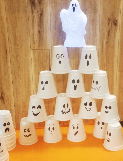 Halloween STEM activities shows a tower made from styrofoam cups with ghosts drawn on.