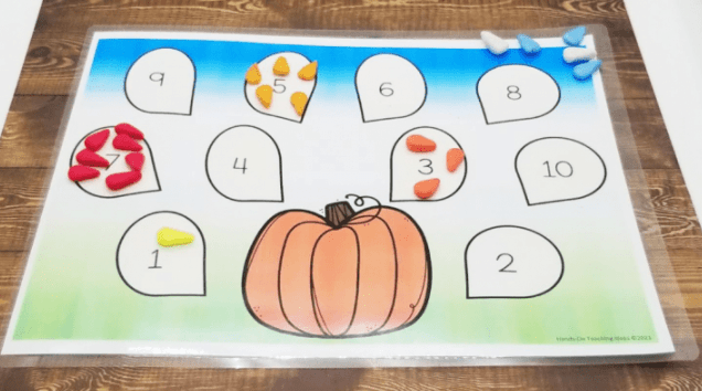 kindergarten worksheets for math shows a pumpkin and numbers 1-10 with pumpkin seeds sorted on top.