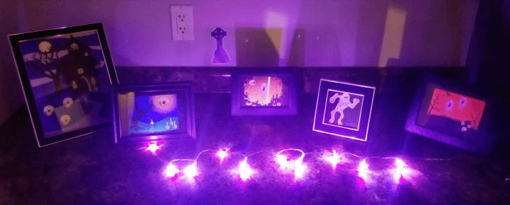 Make a Halloween Escape Room shows purple lights and picture frames from the escape room game.