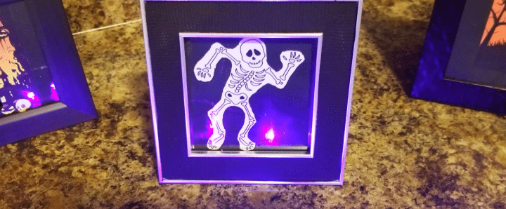escape room ideas shows a picture frame and a skeleton dancing in it.