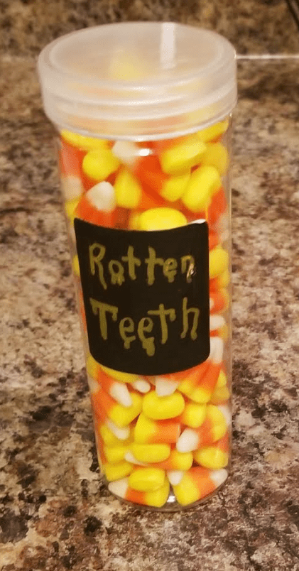 escape room shows a container with a label rotten teeth and candy inside.
