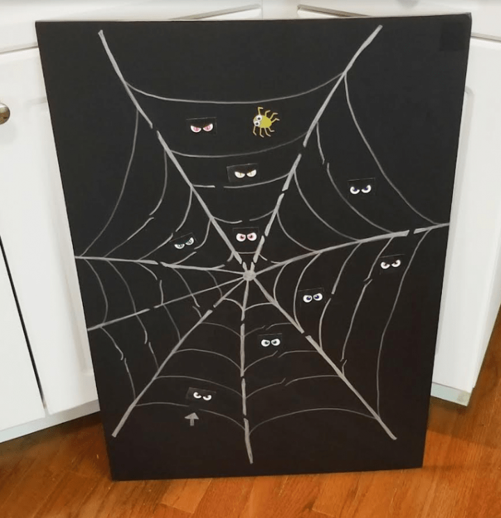 make a halloween escape room shows a spider web with eyes over it.