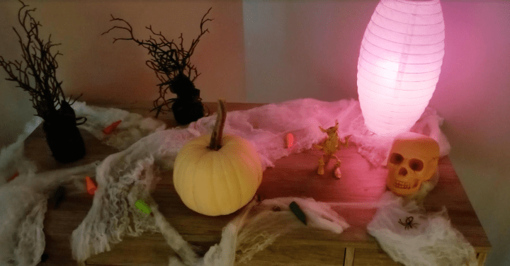 Make a Halloween Escape Room at Home shows a lit up table with Halloween decorations.