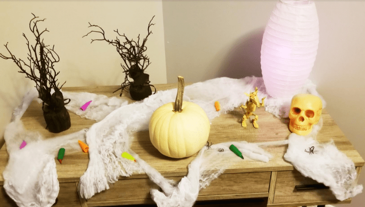 Make a Halloween Escape Room at Home shows a lit up table with Halloween decorations in the light.