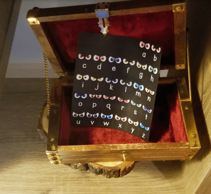 make a halloween escape room shows a treasure box with a puzzle with eyes on it.
