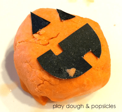 science sensory activity shows an orange ball of playdough with a jack lantern face stuck on it. 