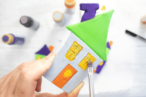 easy crafts for kids shows a person painting a house.