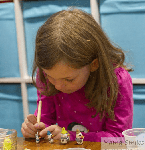 crafts for kids shows a child creating a snowmen. 