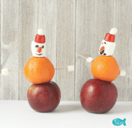 Christmas STEM shows a snowman made from an orange, apple and marshmallow.