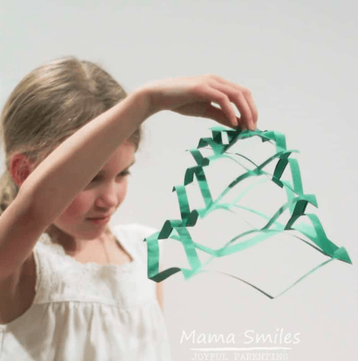 STEM shows a child holding a shape made from paper.