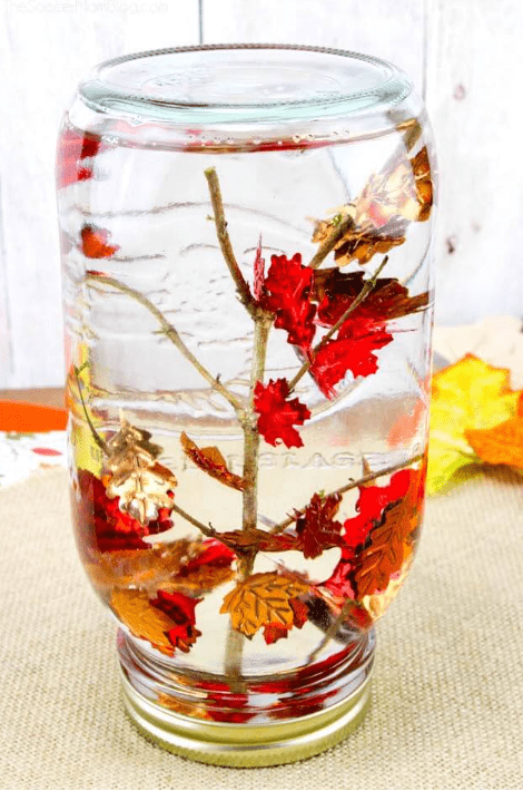 fall centers for kindergarten shows a clear jar with a twig and plastic leaves glued on.