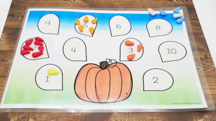 free kindergarten worksheets shows a child counting the seeds with them.