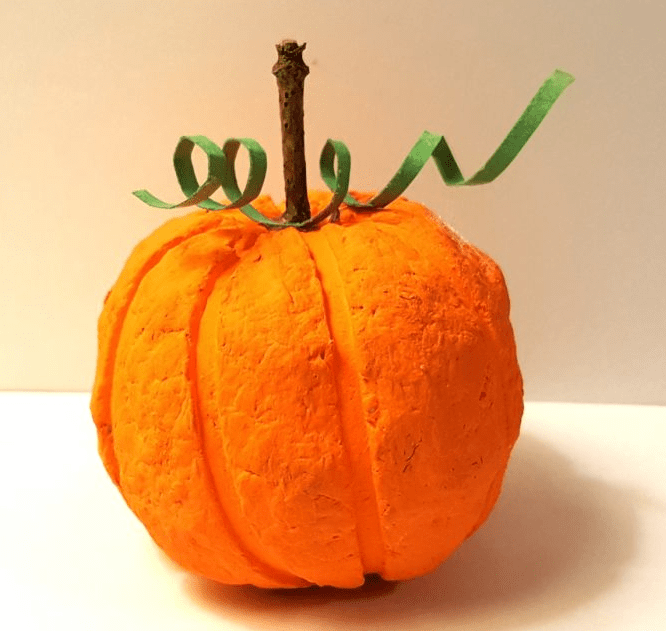 fall sensory play shows a pumpkin made from recycled paper.