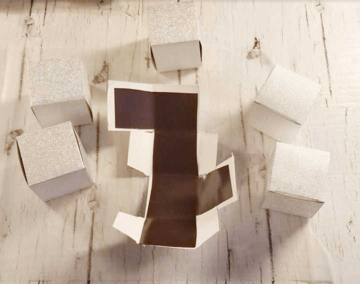 DIY Christmas Escape Room shows folded gift boxes and one lined with magnet paper.