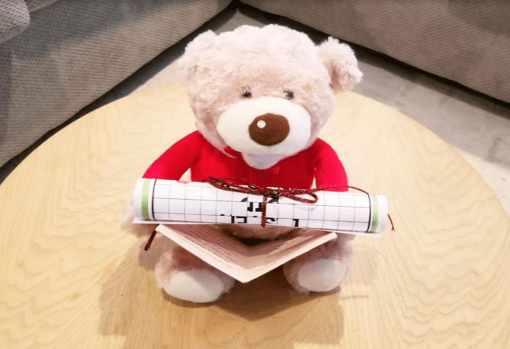DIY Christmas Escape Room shows a little Christmas teddy with a scroll on its lap.