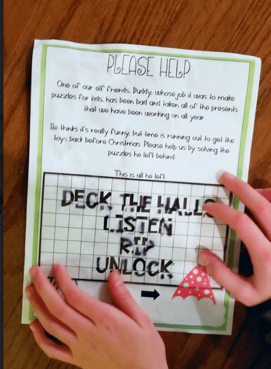 DIY Christmas Escape Room shows a printed puzzle page with a transparency on top.