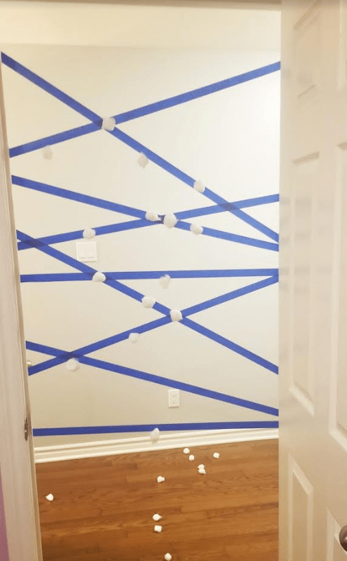 family games to play at home shows a door frame with tape across with cotton balls stuck to it.