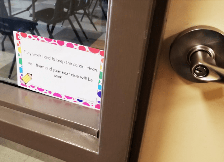 school escape room shows a clue card on a window beside a door handle.