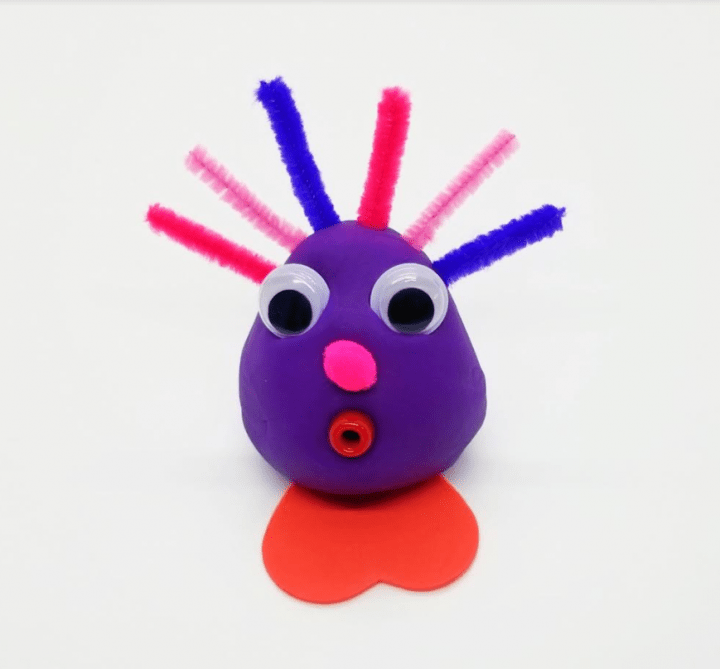 valentines stem activity shows a purple lovebug with pipecleaners and googly eyes.