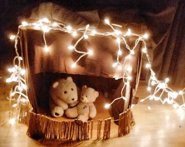 going on a bear hunt shows two bears in a cave with a string of lights around.