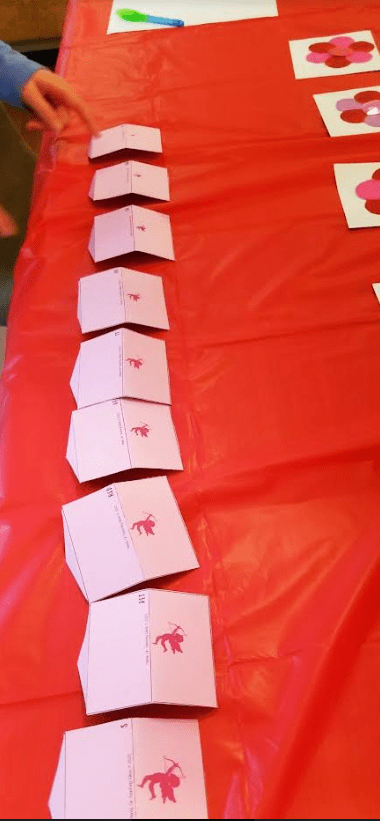 diy valentines day escape room shows a line up of valentines on a table.