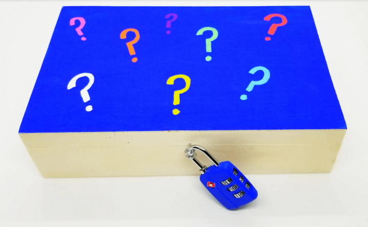 how to make an escape room lock box ideas shows a colorful lock box with question marks on the top.