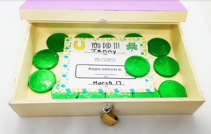 st. patrick's day escape room shows a box with a completion certificate in it and chocolate coins.