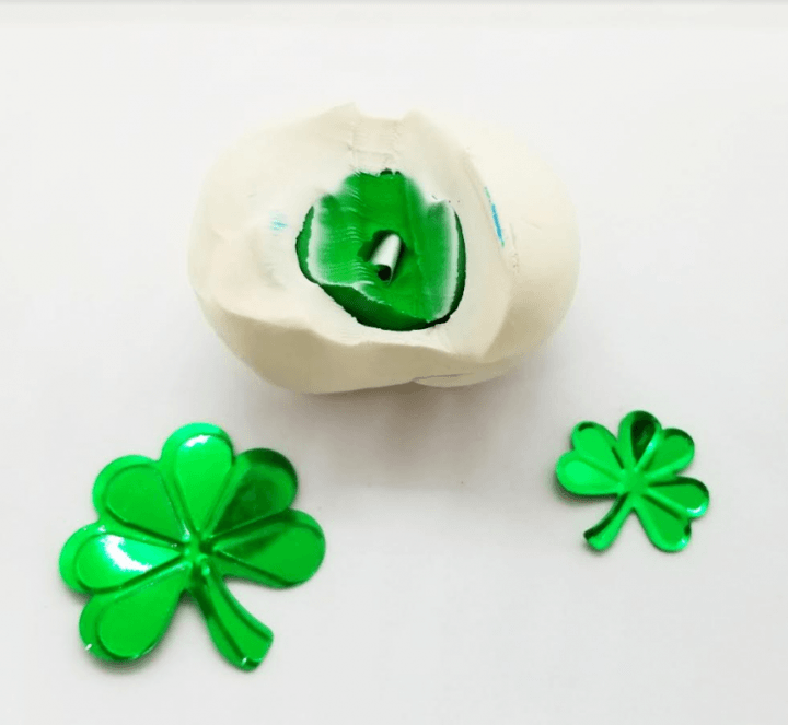 st. patrick's day escape room shows a ball of clay cut open to revel a paper clue.