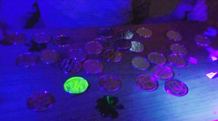 escape room ideas shows a dark image of coins and one of the coins is glowing.