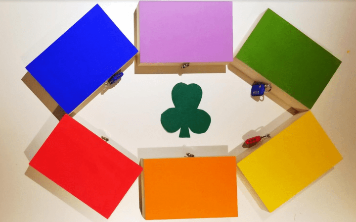 st. patrick's day escape room shows six colorful boxes in a circle.