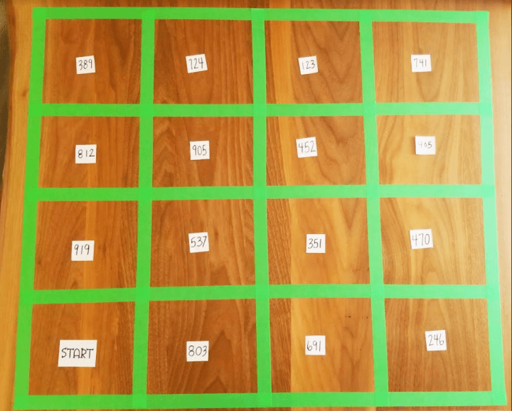 escape room puzzles shows a grid made from tape with numbers on pieces of paper in each square.