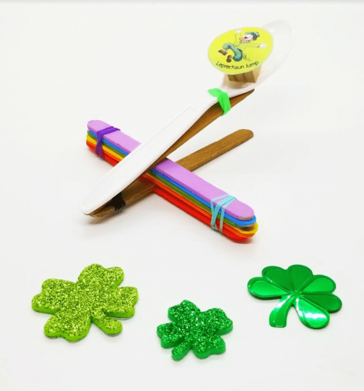 St. patricks day for kids shows a rainbow catapult with a few shamrock cut outs around it.