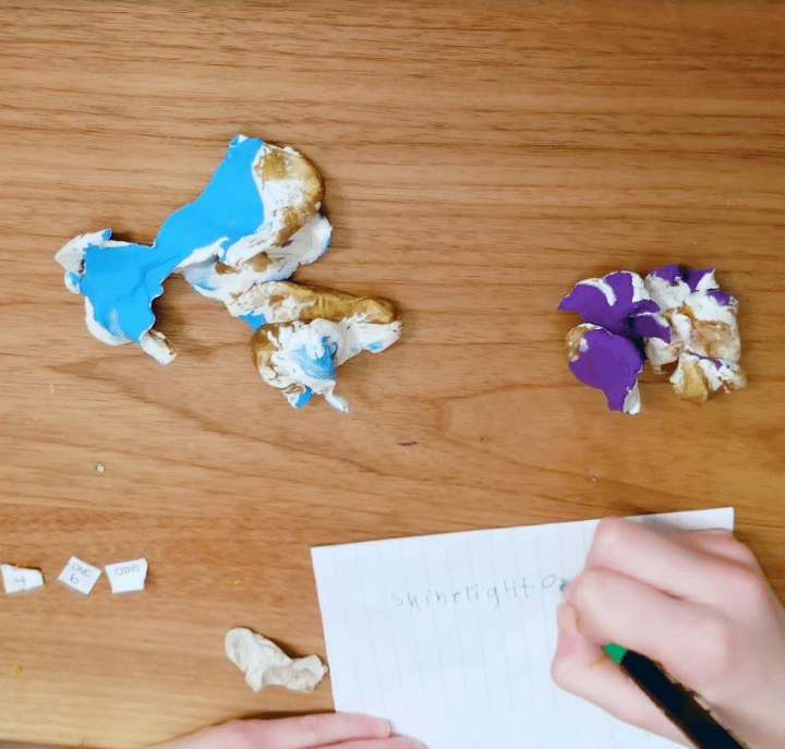 diy escape room shows clay that has been ripped apart and a child printing letters on a page.